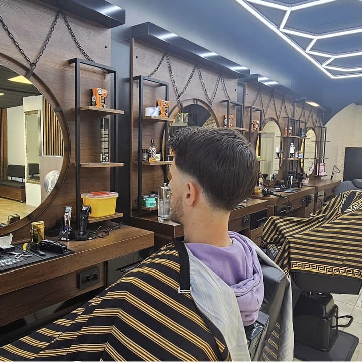 Low Fade mit längerem Deckhaar, Seitenansicht im Salon