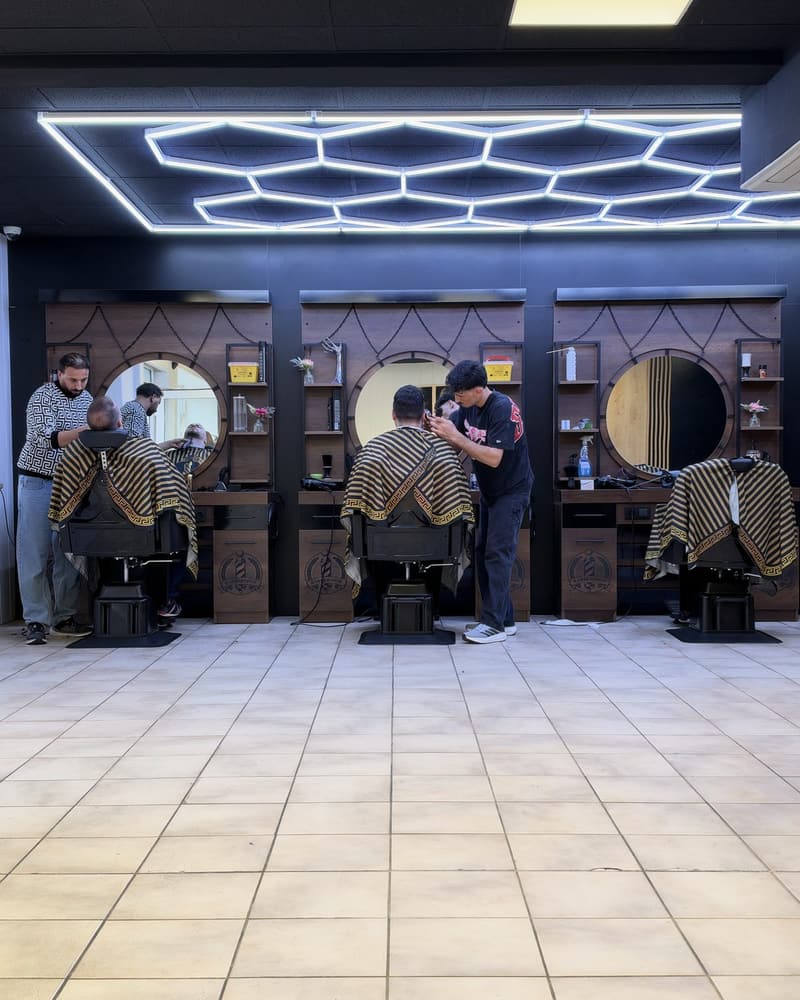 Der Prince Barber Shop in Erding: drei Stationen mit runden Spiegeln unter der sechseckigen LED-Lichtdecke